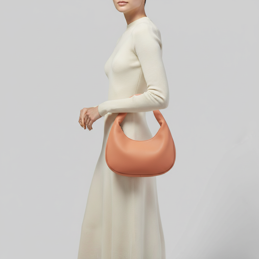Heritage Curve luxury curved handbag in Coral Peach – female model carrying bag